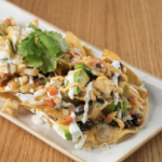 RASCAL CHICKEN & CHEESE NACHOS ~ Individual chicken nachos with pico de gallo, jalapeno, cheddar cheese, olives, avocado, sour cream, fresh lime